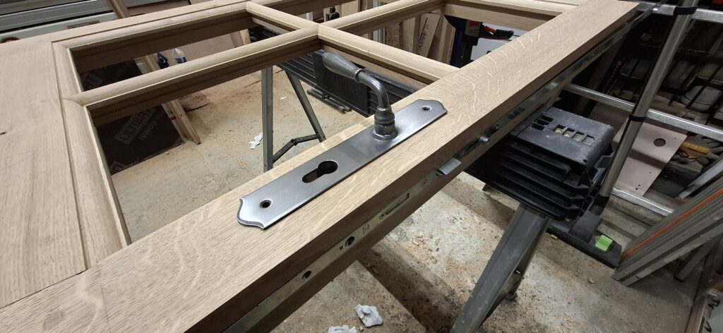 Poignée de porte sur menuiserie chêne traditionnelle